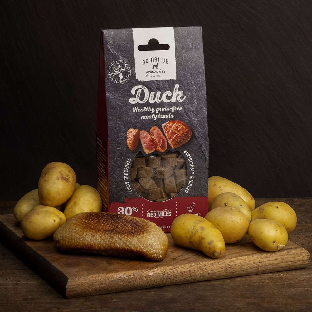 Go Native Duck Dog Treats 100g pack with duck breast and potatoes on a wooden board