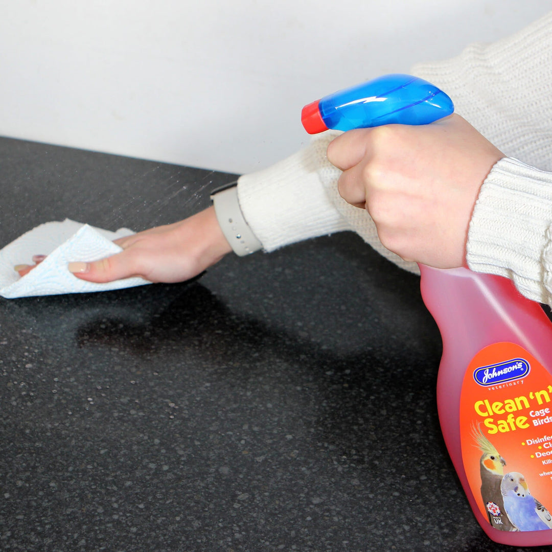 Johnson's Clean 'n' Safe disinfectant being sprayed and wiped on a surface